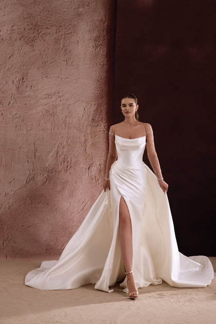 The Aylin bridal dress in satin with a front slit and sculpted silhouette radiates sleek contemporary elegance.