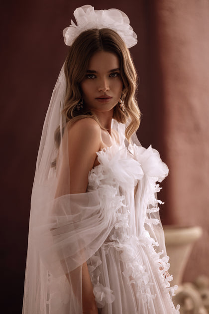 The Bella bridal dress featuring a leg slit and 3D floral corset embodies modern femininity and soft elegance.