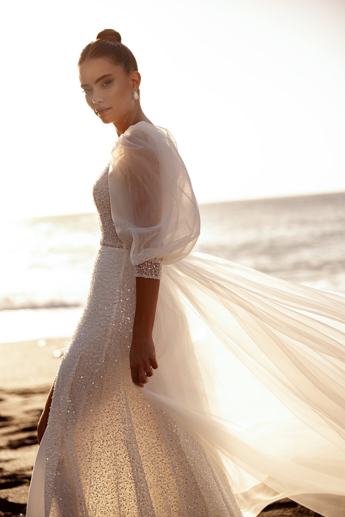 Side view of Davina wedding dress, with shimmering fabric and mid-length puff sleeves