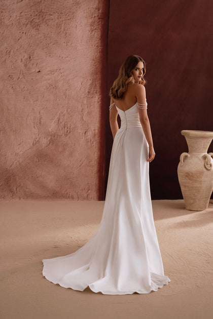 The back view of the Eleonore bridal gown shows a graceful train and refined tailoring for a chic, minimalist aesthetic.