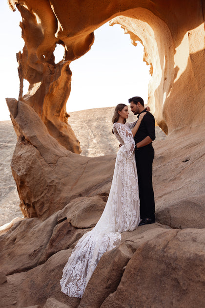 The Dune bridal gown showcases a lace bodice and wide sleeves with delicate embroidery, blending vintage charm and bohemian spirit.