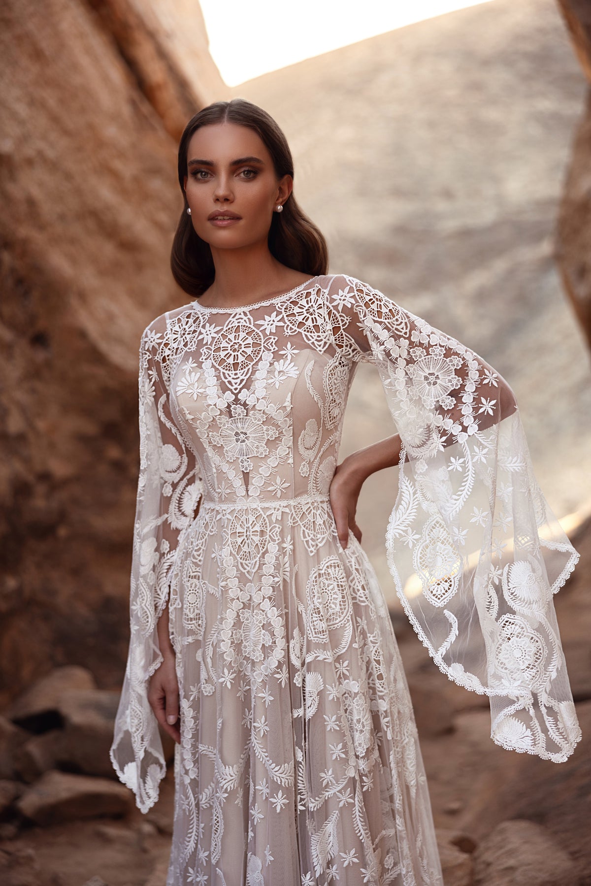 Front view of Dune wedding dress, with a high neckline and wide flared lace sleeves