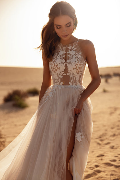 The Ellie wedding gown combines a halter bodice and light tulle skirt for a graceful, bohemian bridal look.