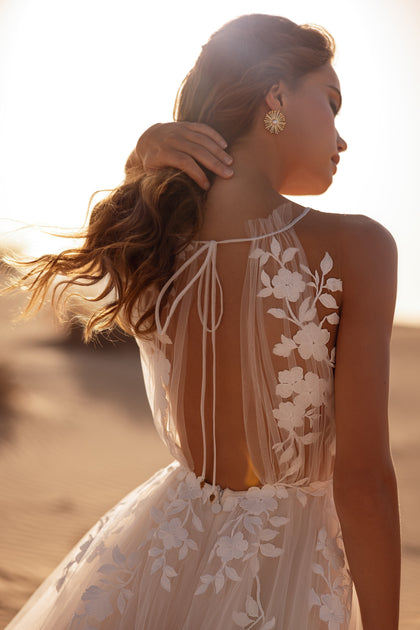 The Ellie bridal gown captures the sunset glow with its sheer lace bodice and ethereal tulle movement.