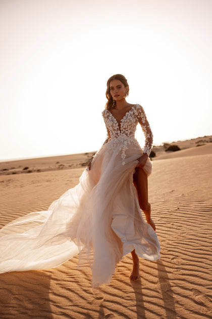 The Farida wedding dress features a sheer lace bodice and soft tulle skirt, perfect for a romantic and graceful bridal style.