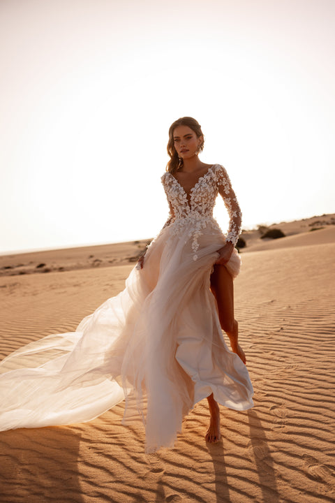 The Farida wedding dress features a sheer lace bodice and soft tulle skirt, perfect for a romantic and graceful bridal style.