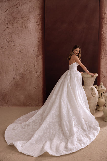 The Hebe bridal dress merges traditional princess style with contemporary touches such as side pockets and rich jacquard fabric.