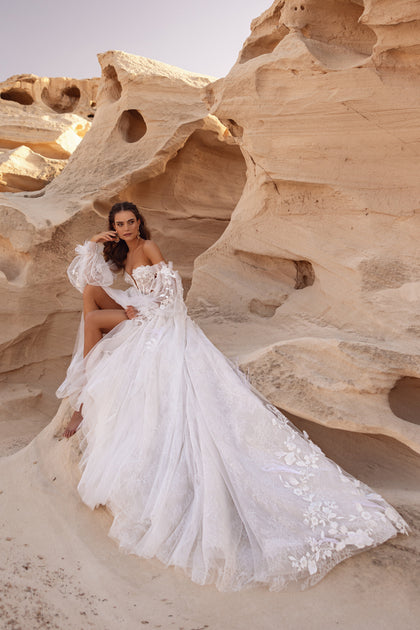Detail shot of the Huda bridal gown shows lace embroidery, corset ties, and textured floral appliqué.