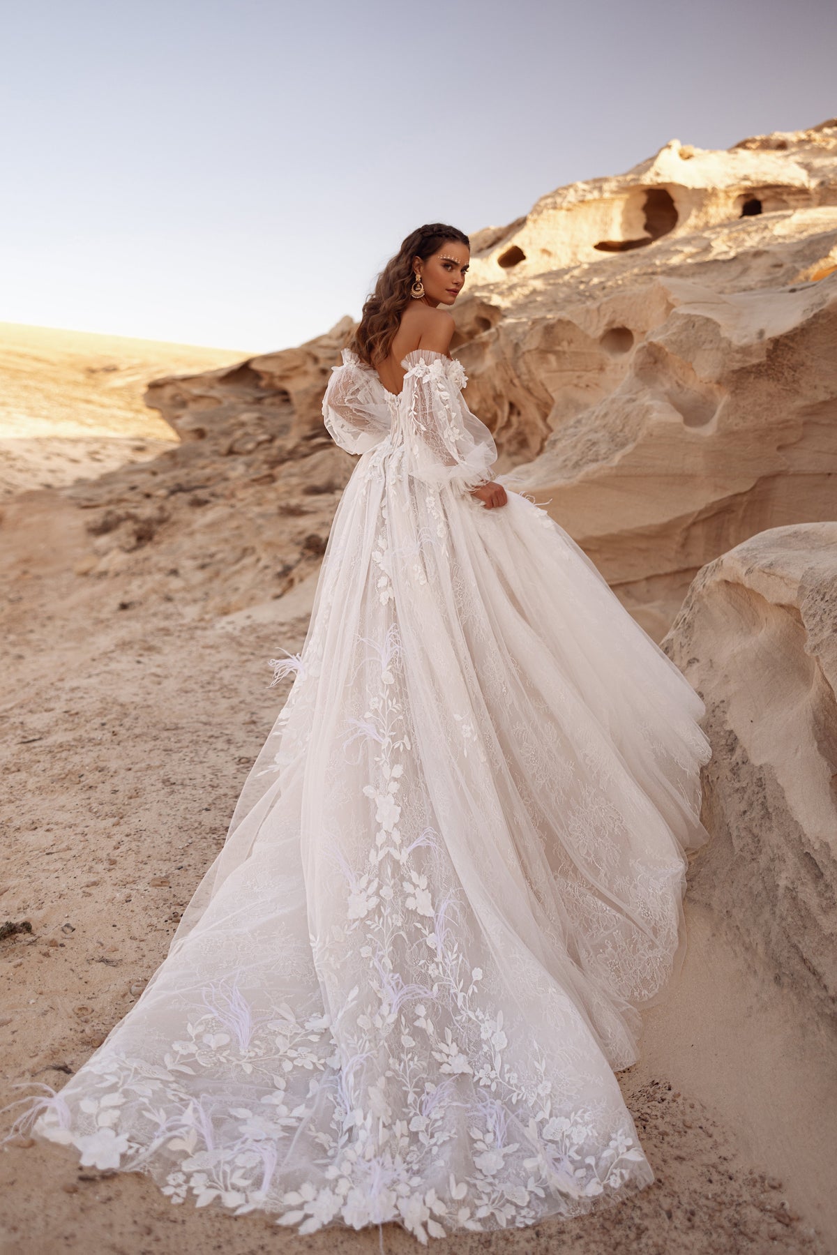 Huda wedding dress from behind, with floral lace running down the tulle skirt to the end of the train