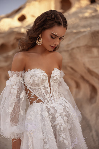 The Huda bridal dress with off-shoulder neckline and corset bodice combines romance with bohemian sophistication.