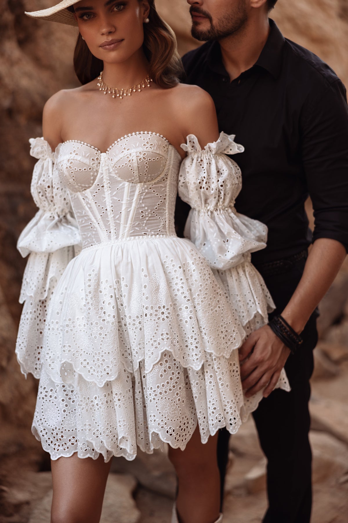 Bride in Jolene short lace wedding dress with puff sleeves and a hat, beside the groom