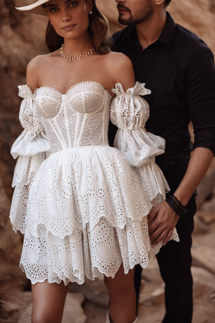 The Jolena bridal gown features an open back with corset lacing and off-shoulder puff sleeves for a feminine boho look.