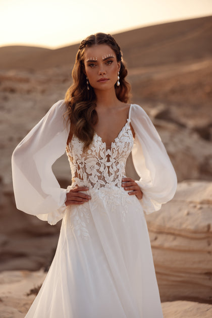 The Judith bridal gown with a lace corset and flowing chiffon sleeves embodies ethereal bohemian elegance.
