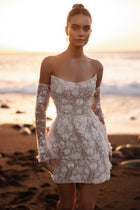 The Kayla bridal gown with off-the-shoulder design and delicate floral appliqué captures the essence of coastal romance.