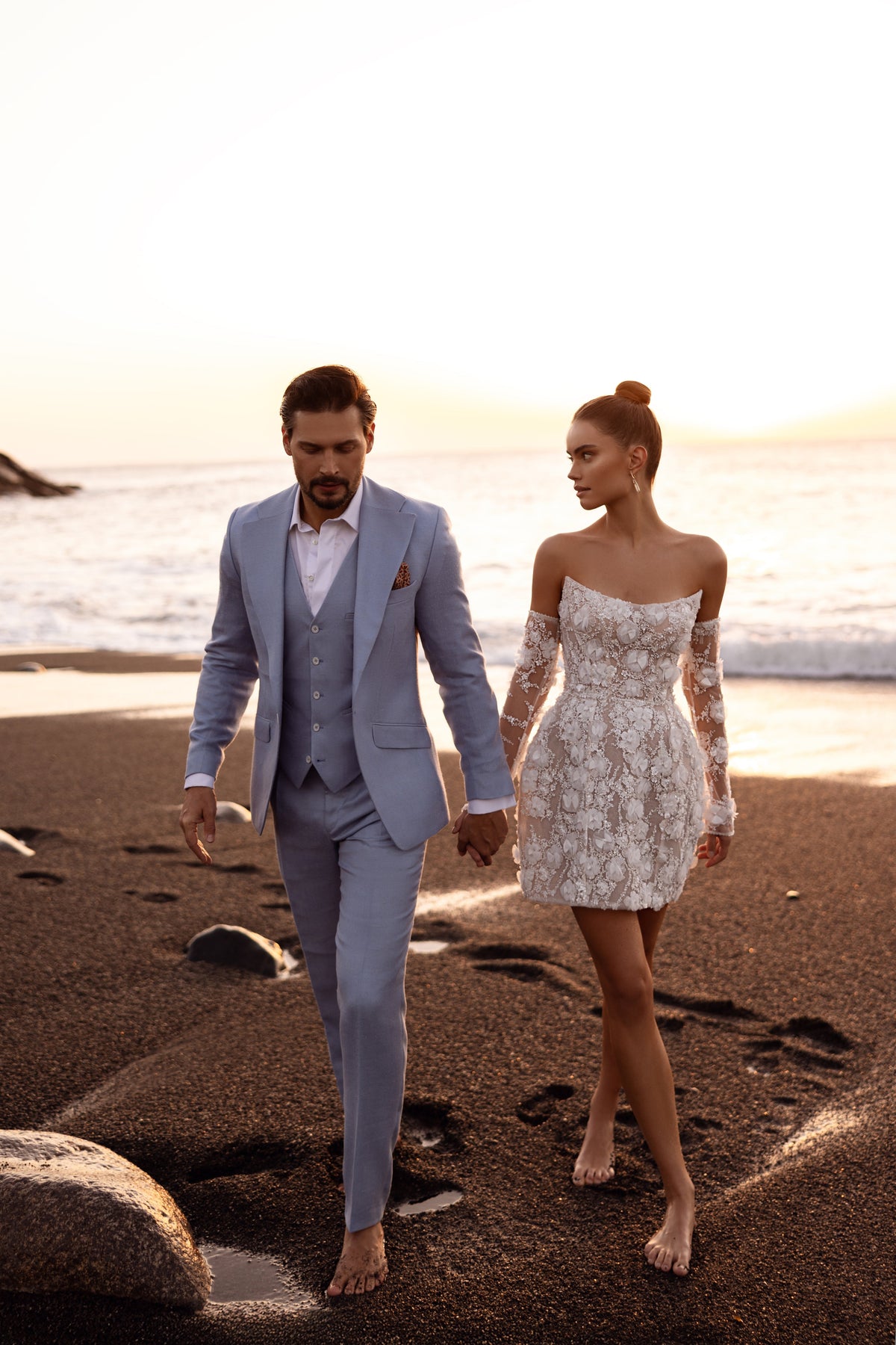 Bride and groom on the beach, with the bride in Kayla short floral lace wedding dress
