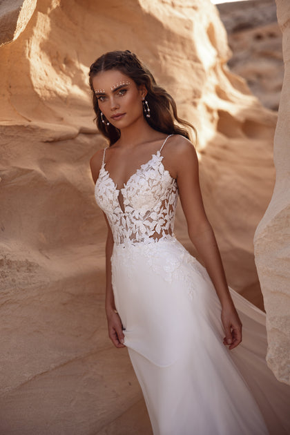 The Malika gown’s open lace back creates a romantic and graceful bridal aesthetic.
