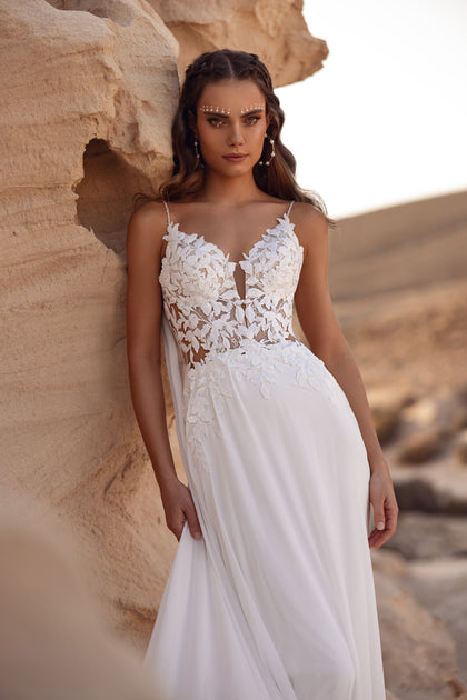 The Malika wedding dress with its intricate lace leaf train evokes effortless romance.