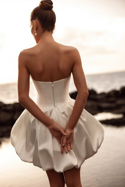 Martini mini bridal gown with a low back and balloon skirt expresses refined minimalism and contemporary allure.
