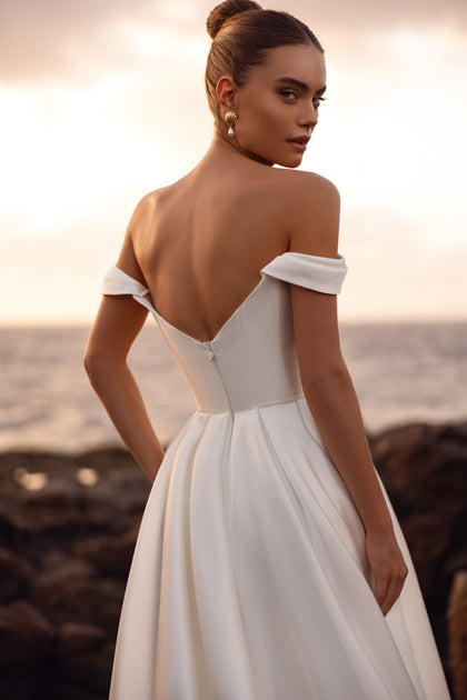 Mellisandre bridal gown with an off-the-shoulder design and low back, exuding classic sophistication and romance.
