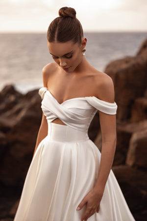 Mellisandre off-the-shoulder wedding gown featuring a softly draped bodice for a refined and romantic bridal look.