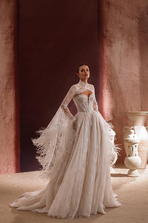 The Michelle lace bridal bolero with intricate embroidery highlights the bride’s elegant silhouette.