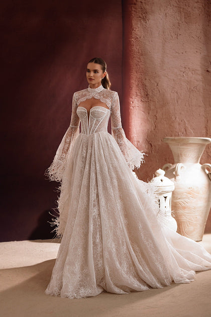 The Michelle bridal gown from the Zahra al-Sahra collection showcases a flowing lace train and delicate feather accents, perfect for an elegant, romantic bride.