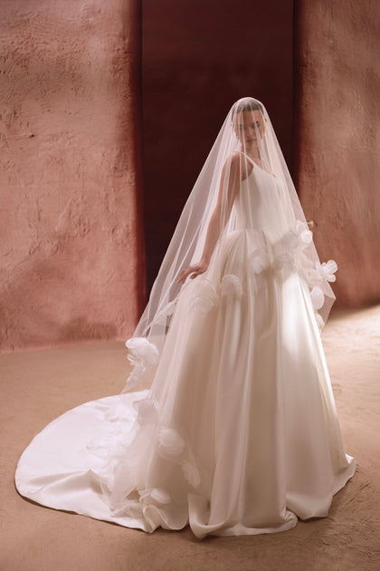 The Nicolette bridal gown with a long veil decorated with floral appliqués exudes pure romance and grace.