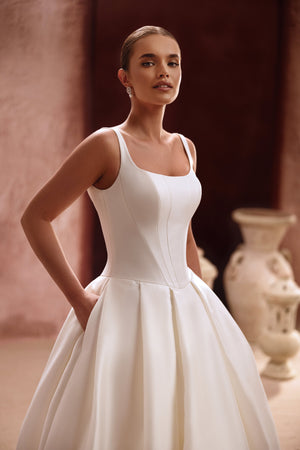 The Nicolette bridal dress with a square-cut neckline and fitted bodice enhances the waist for a refined, graceful look.