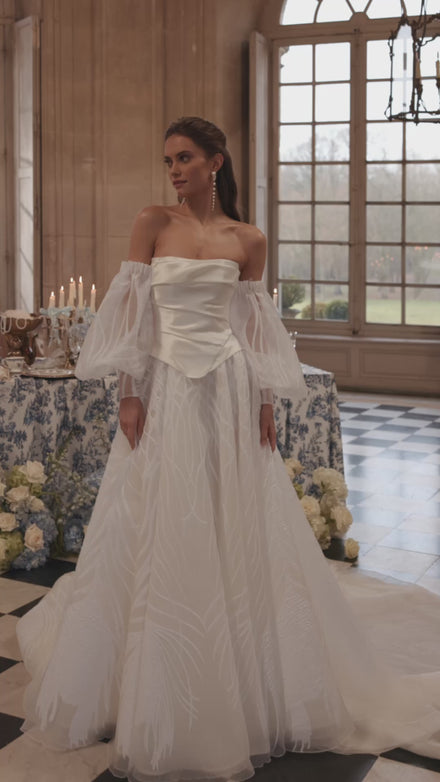Video of the Charlize corset in motion – A-line silhouette with a clean strapless corset worn with voluminous off-the-shoulder sleeves.