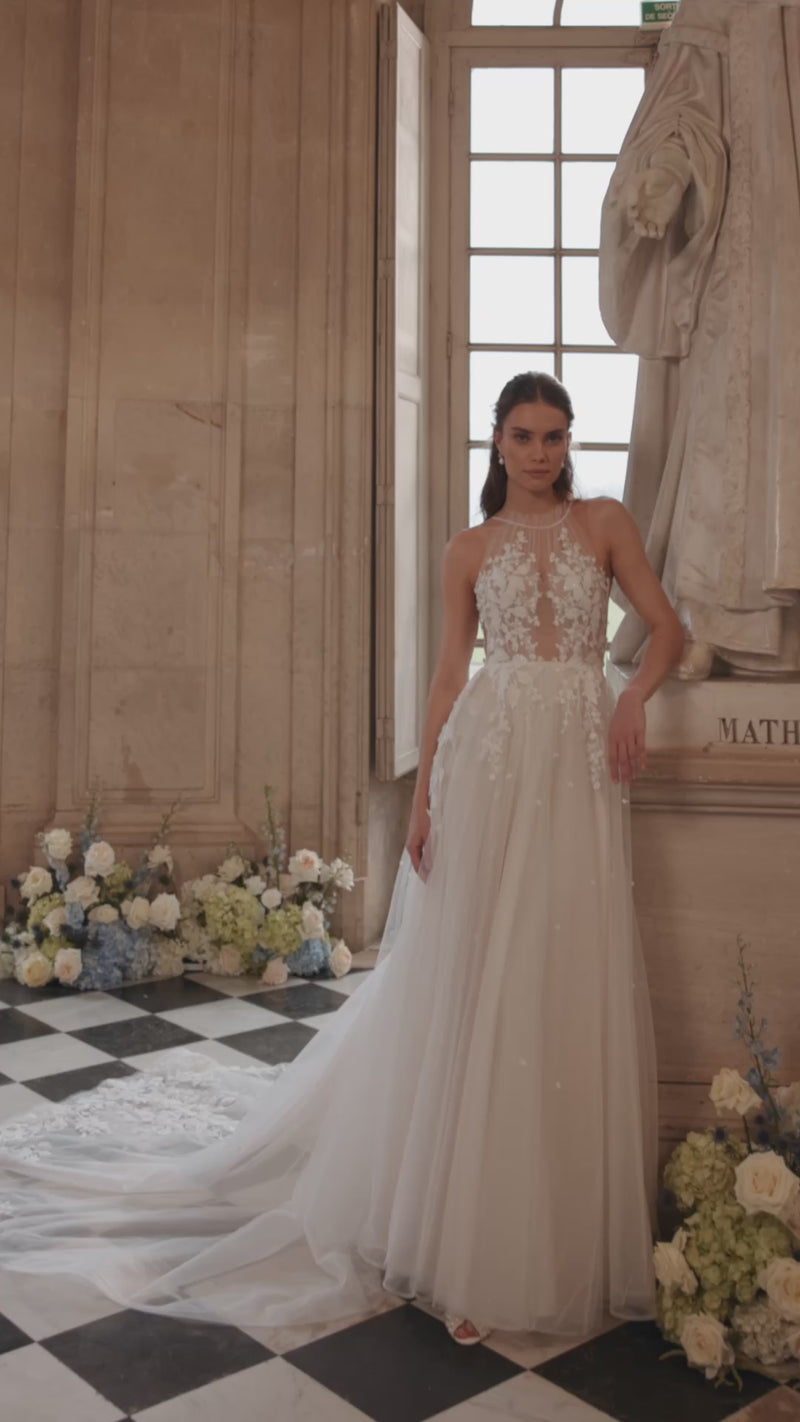 Video of the Nilla wedding dress in motion – A-line silhouette with a sheer high neckline and floral lace tulle skirt.