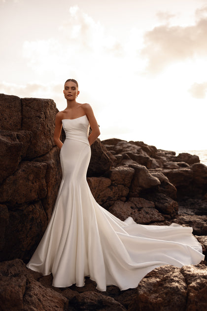 The Soraya fishtail bridal gown with an open back beautifully accentuates the feminine silhouette at sunset.