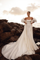 The Soraya bridal gown featuring voluminous sleeves and sweeping train captures timeless grace and sophistication by the coast.