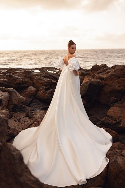 The Soraya wedding dress with statement puff sleeves and fitted silhouette blends contemporary minimalism with artistic design.