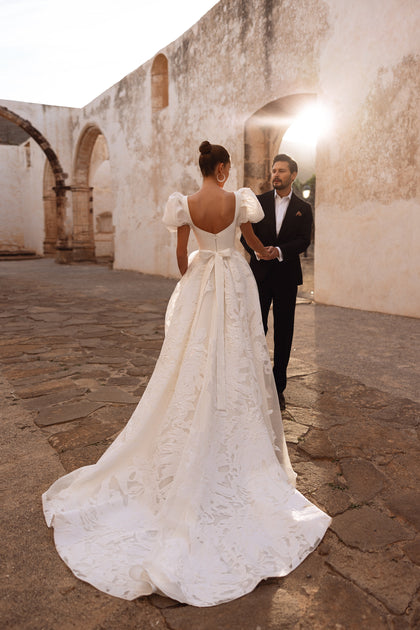 The Vanilla bridal gown featuring a sleek corset and lace-embroidered tulle skirt radiates modern sophistication.