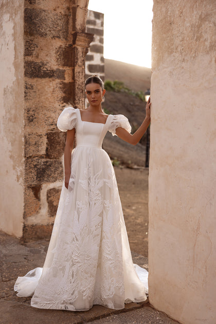 The Vanilla bridal dress featuring an open back and elegant bow accentuates graceful femininity.