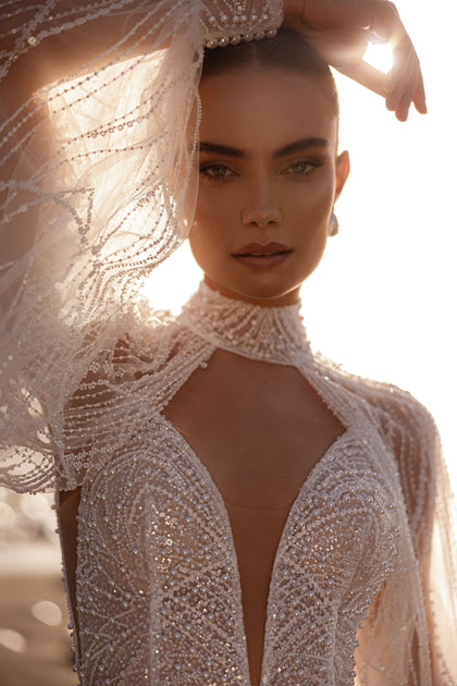 The Venus bridal dress featuring a high neck and plunging neckline blends elegance with modern allure.